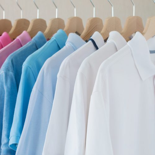 Man's shirts hanging on rack in row
